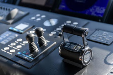A close-up view of a yacht or ship bridge with the throttle controls. The navigation radar screen...