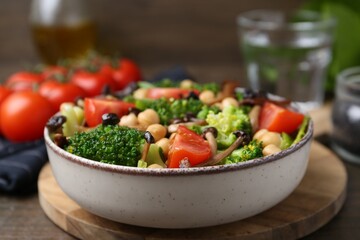 Delicious salad with shimeji mushrooms, chickpeas, tomatoes and broccoli on table, closeup
