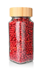 Red peppercorns in glass jar isolated on white. Aromatic spice