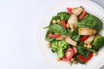 Tasty salad with eryngium mushrooms, chickpeas, vegetables and spinach on light table, top view. Space for text