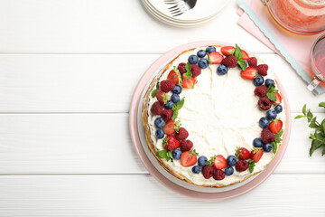 Delicious crepe cake with fresh berries served on white wooden table, flat lay. Space for text