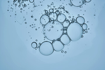 The texture of the hyaluronic serum on a blue background. A drop.