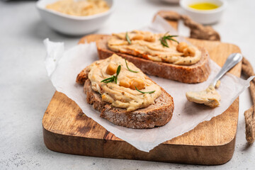 Delicious sandwiches with hummus and ingredients on white table, flat lay. High quality photo