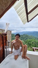 Man enjoying an outdoor bubble bath with mountain view on a transparent background