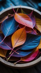Overhead shot of colorful autumn leaves in a wooden bowl, showcasing the vibrant hues of fall foliage and the beauty of natures transition