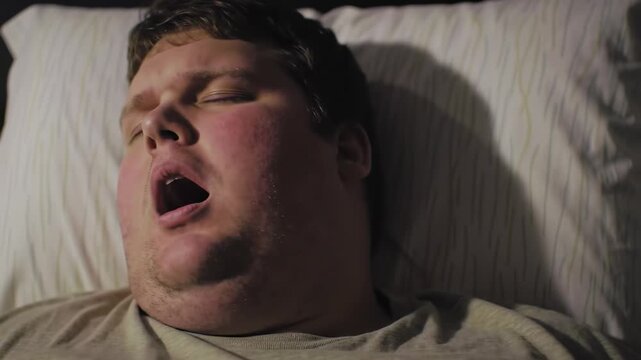 Sleepy man yawning in bed