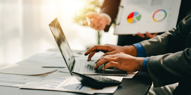 Young colleagues discussing business and price chart analyzes business people on the table great in modern coworking office teamwork concept. Calculate personal tax for customers