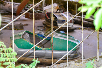 Old playground with rusty green carousel behind metal fence, abandoned vibe.