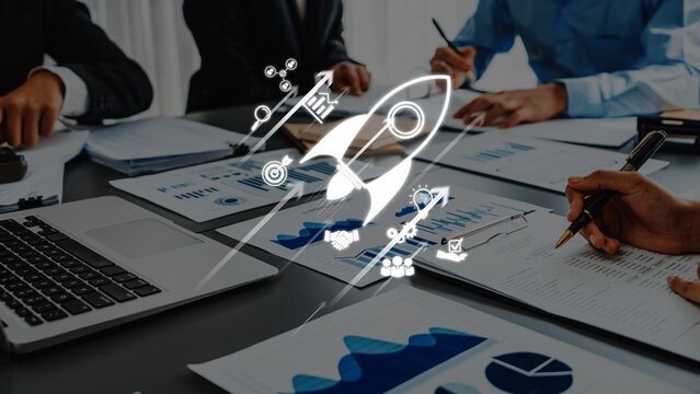 A dynamic business meeting showing a team collaborating on growth strategies with documents and a laptop, symbolized by an innovative rocket icon for inspiration. Raster