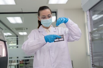 Scientist conducts research in laboratory with precise handling of samples during work hours