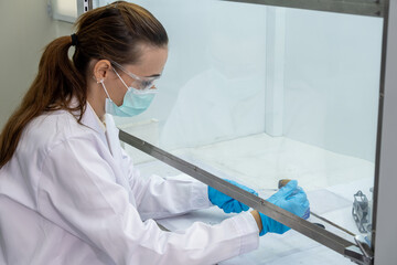 Research scientist performs laboratory experiments in a controlled environment with safety gear and tools