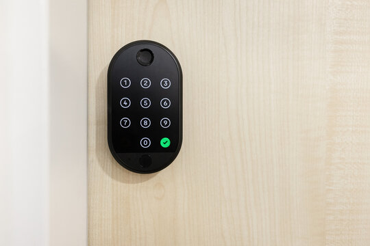 Smart lock keypad installed on wooden door. Modern digital security solution for smart homes, providing safe access control and innovative technology convenience