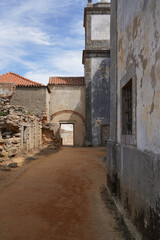 Old religious structure with archway on the coast of Portugal. Stone architecture, spires, pathway, historic atmosphere, religious symbolism, peaceful scene.