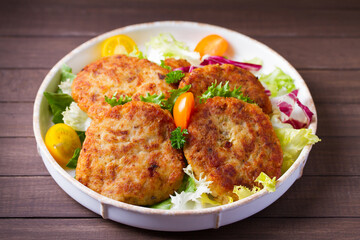 Fish patty burgers served with vegetables. Fish cakes