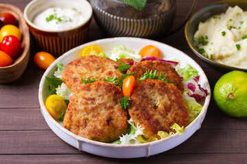 Fish patty burgers served with vegetables. Fish cakes