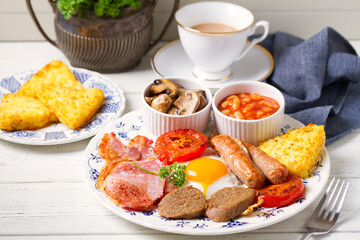 Classic traditional Irish or English breakfast with sausages, bacon rashers, white pudding, beans and grilled tomatoes