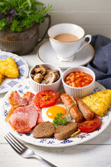 Classic traditional Irish or English breakfast with sausages, bacon rashers, white pudding, beans and grilled tomatoes