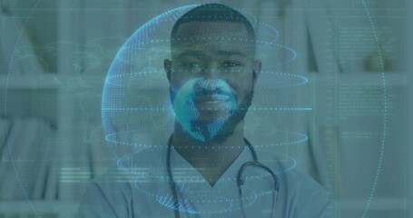 Standing male doctor wearing scrubs projecting digital globe data at clinic, with stethoscope