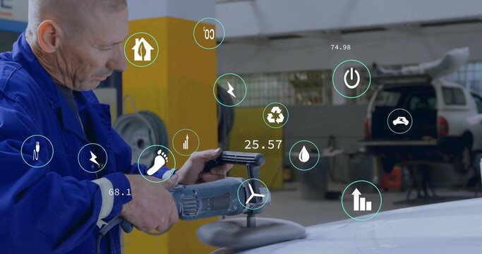 Fototapeta Mechanic in coveralls polishing car roof using electric polisher in garage, energy icons copy space