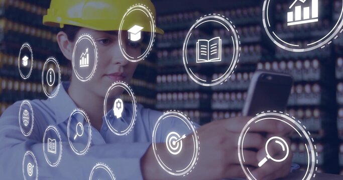 Examining smartphone female technician wearing safety helmet and shirt in depot with floating icons - Powered by Adobe