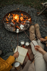Family roasting marshmallows over a campfire on a cozy autumn evening.