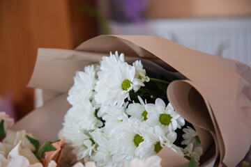 Bouquet of white chrysanthemums in kraft paper