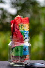 Swiss franc CHF banknote saving money in glass jar. Consumption and economy