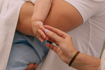 Obraz premium A baby touches an adult. A tender interaction symbolizing trust and parental love. Perfect for themes of motherhood, care, family, togetherness.