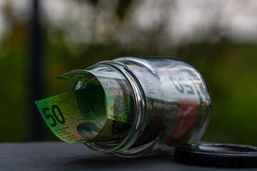 Fototapeta premium Swiss franc CHF banknote saving money in glass jar. Consumption and economy