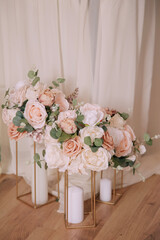 Elegant wedding floral arrangements in pastel colors with gold stands and candles.