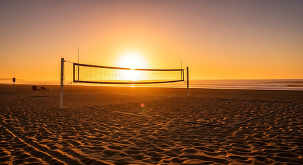 A volleyball net stands silhouetted against a vibrant sunset over a sandy beach, creating a serene scene.