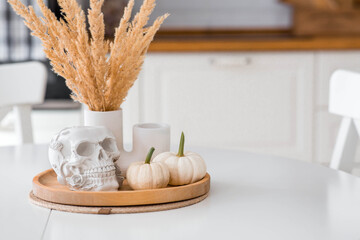 Halloween celebration. A white skull and pumpkins on the table. Decor for the Day of the Dead or...