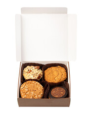 Open box containing four different homemade cookies with transparent background
