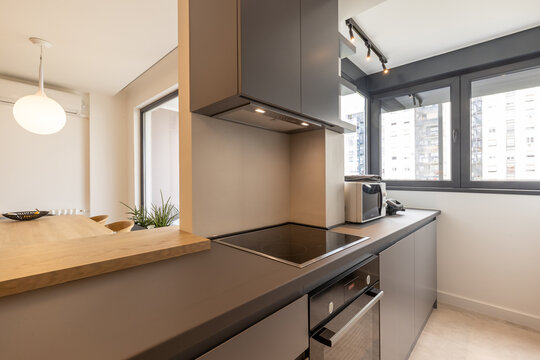Modern kitchen with built-in appliances and large windows