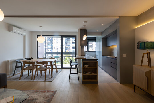 Interior of a modern open-plan kitchen and dining area with city view