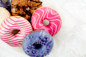 Colorful donuts with various toppings arranged on a white background