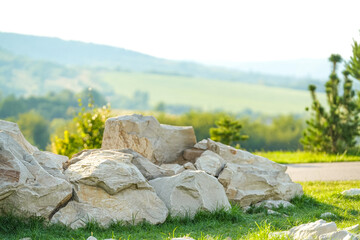 Large rocks near a grassy area with rolling hills in the background during a sunny day
