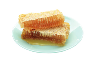 Bowl of sweet honey, dippers and combs on plate isolated on white background.
