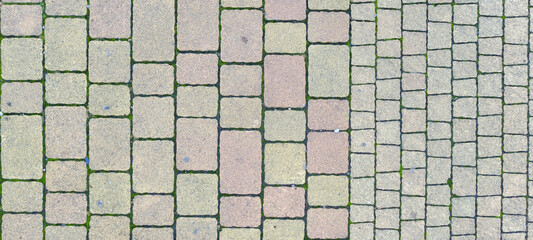 A close-up view of a stone pavement showing various colors and patterns. The interlocking stones create an interesting texture suitable for urban design or landscaping projects.