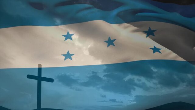 With breeze blowing, Honduran flag rippling past cross silhouette to honor faith and national pride