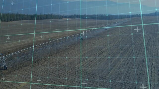 Upon grid overlay appearing, irrigation arm spraying water and moving outward for field watering