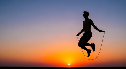 Active man silhouetted jumping rope during vibrant sunset over ocean