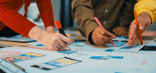 A group of diverse professionals engaged in a collaborative brainstorming session, sketching innovative ideas on paper with markers in a vibrant office space. SACTR