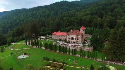 Gorgeous scenery of the Cantacuzino Castle in Busteni, Romania. Aerial perspective on the famous landmark in the lush greenery.