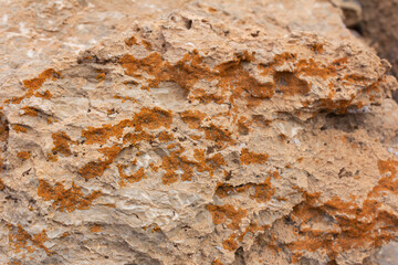Discover the rugged beauty of natural rock formations with vibrant orange lichen, perfect for nature, geology, and outdoor stock photo collections.