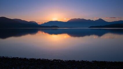 Scenic sunset over a lake with mountains reflecting in water