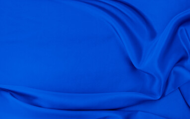 Black blue satin dark fabric texture luxurious shiny that is abstract silk cloth background with patterns soft waves blur beautiful.