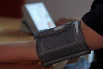 Blood Pressure Monitor Cuff on Left Arm Measuring Hypertension.