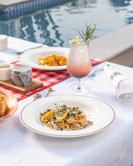 Authentic Italian pasta, being served with other pastas in the background on a restaurant table with cocktails