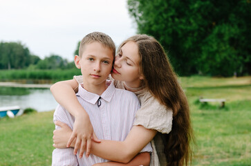 Fototapeta premium A handsome boy and girl are hugging, brother and sister